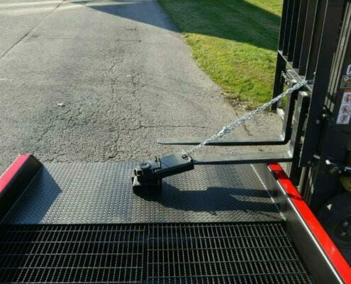 Semi truck ramp positioning sleeve with chain attached to forklift